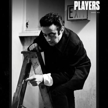 A man in a dark coat stands on a wooden ladder, holding a cigarette. An EXIT sign is visible behind him. The image is black and white with the NEW CITY PLAYERS logo in the top right corner.